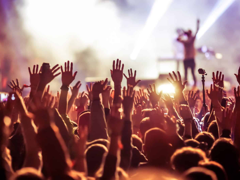 Concert-goers with their arms in the air